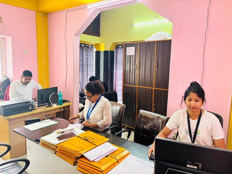 Staff reviewing documents at the long desk on the main floor.