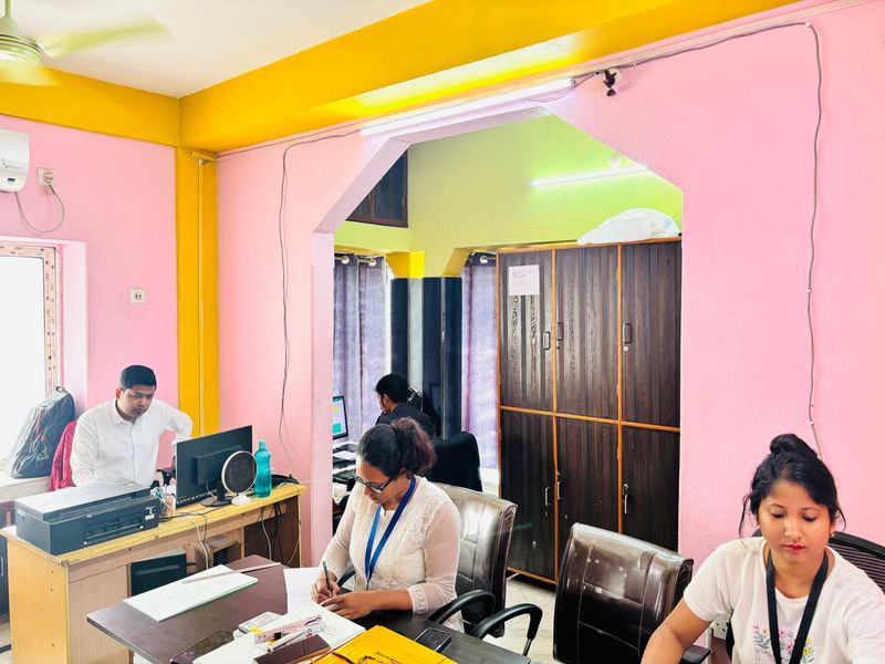 The main office floor, with staff at their desks and matter files stacked beside them.